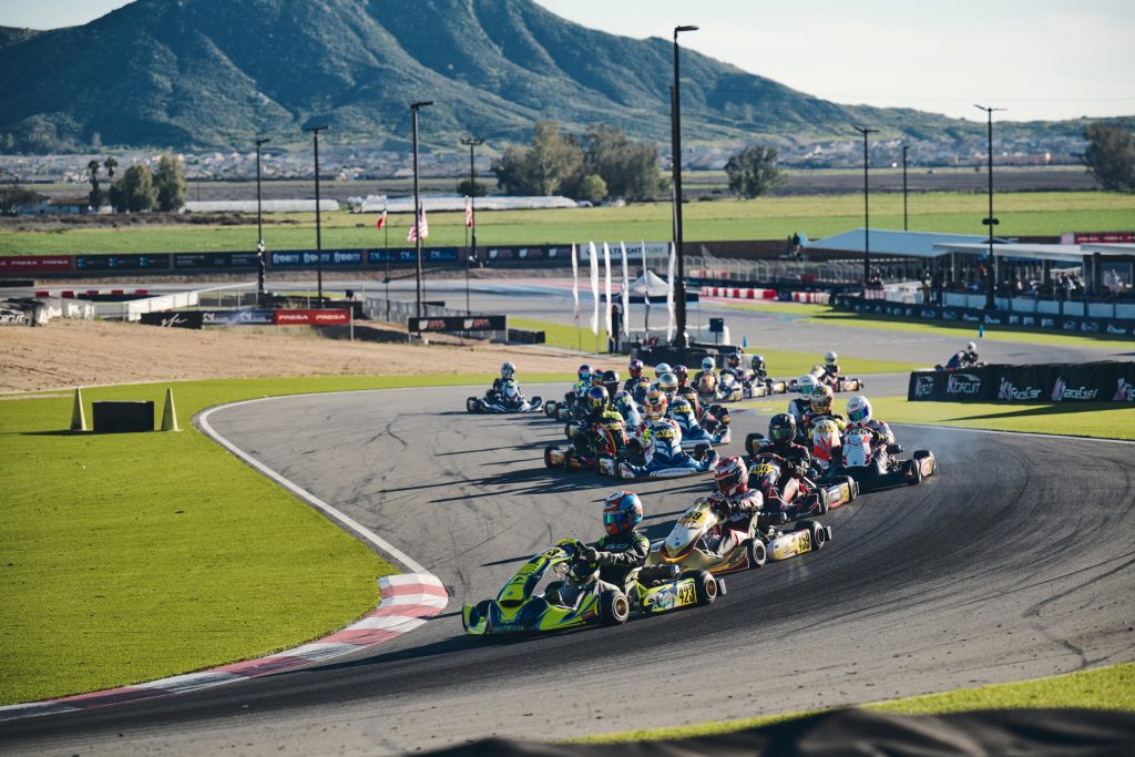 A large group of go-karts race through the first turns at K1 Circuit during the second round of Champions of the Future America