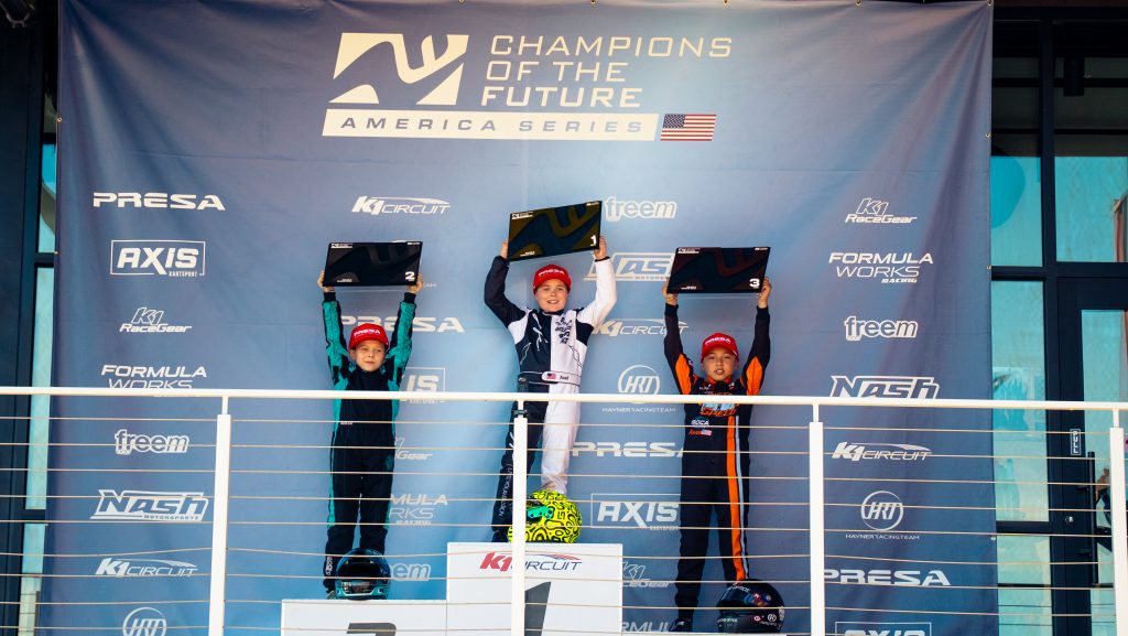 Axel Tibbs, Maddux Carlucci, and Asher Biezonsky hold up awards during the Mini podium ceremony for Champions of the Future America Series Round 3 at K1 Circuit