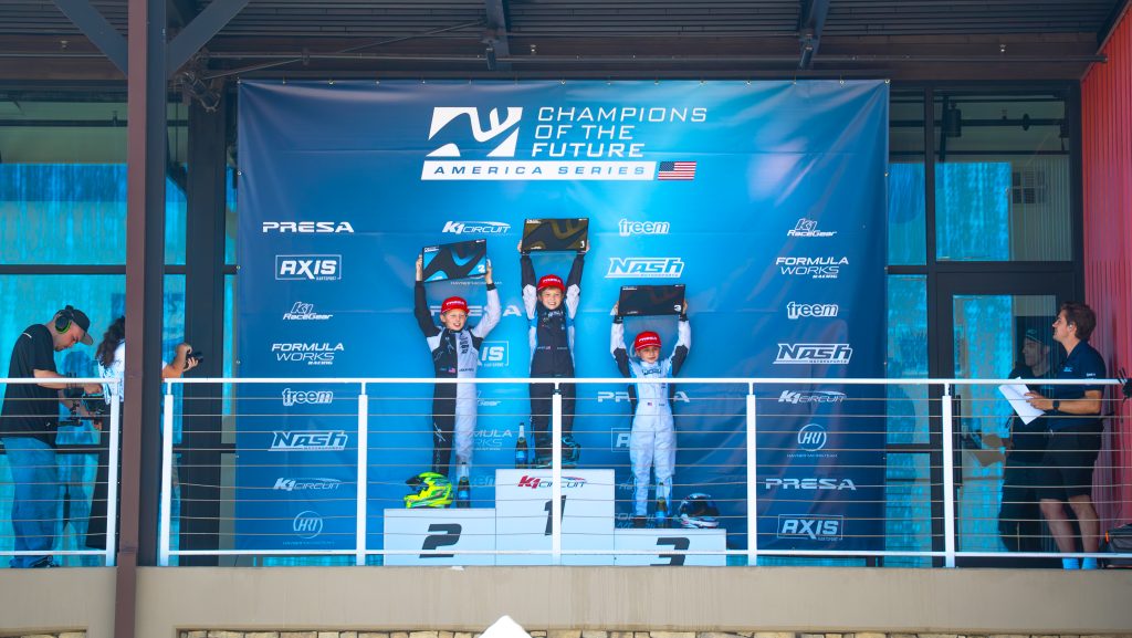 Maddax Carlucci, Lachlan Postle, and Benjamin Tavi stand on the podium at K1 Circuit as the top three finishers of Mini at K1 Circuit, Champions of the Future America Series Round 6