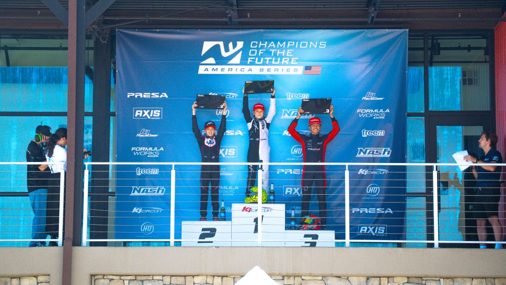 Braydon Wagner, Luis Martinez, and Daniel Ramirez stand on the podium at K1 Circuit as the top three finishers of KA100 Junior at K1 Circuit, Champions of the Future America Series Round 6