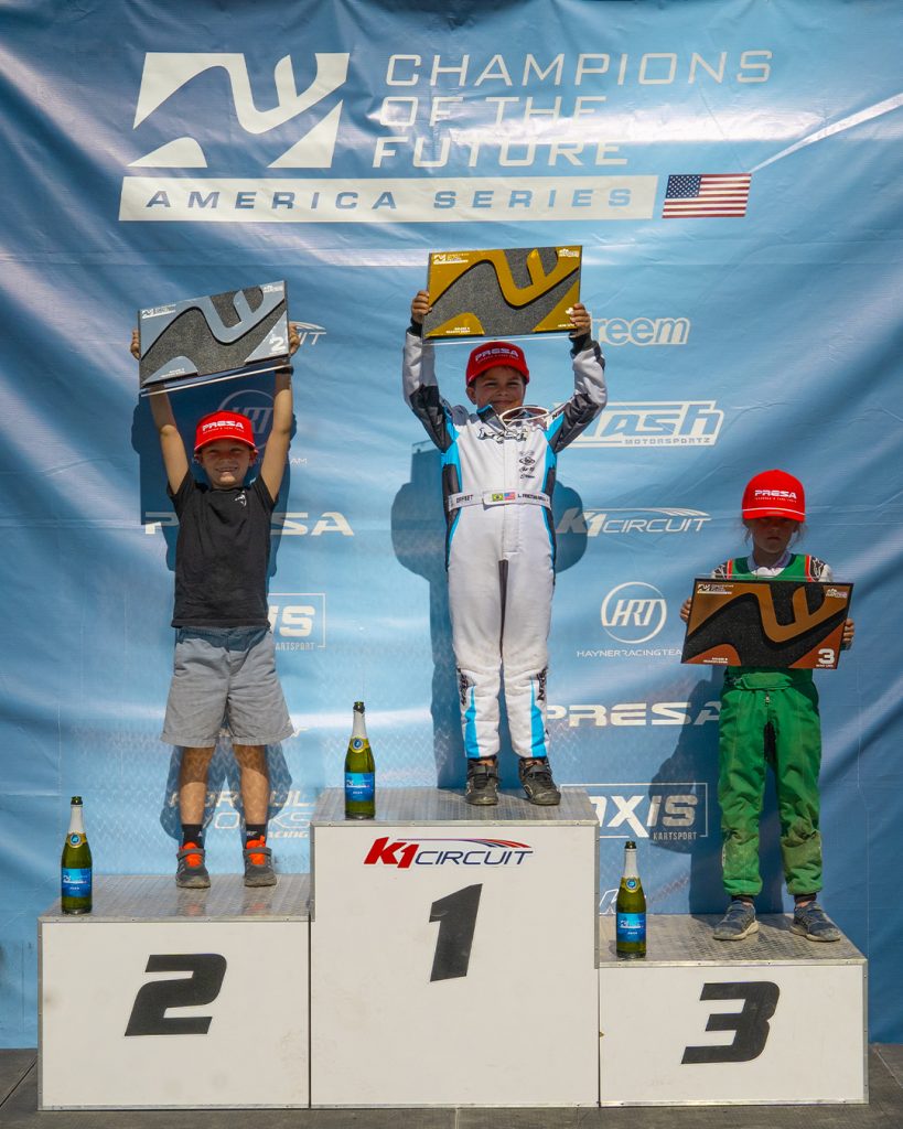 The top three Mini U10 drivers from COTF America's Round 5 event in Pahrump, NV stand on the podium with their trophies