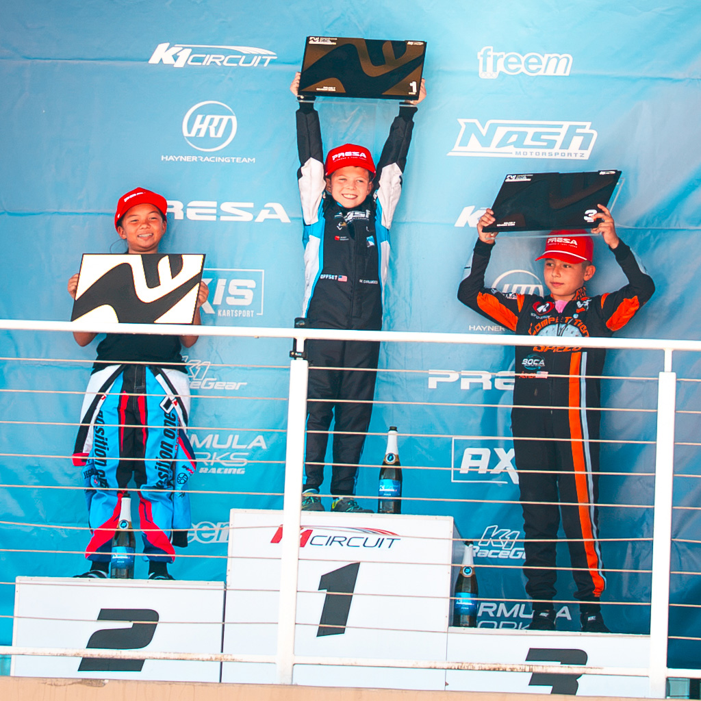 The Top 3 drivers from Mini hold up their trophies on the podium during Round 7 of Champions of the Future America