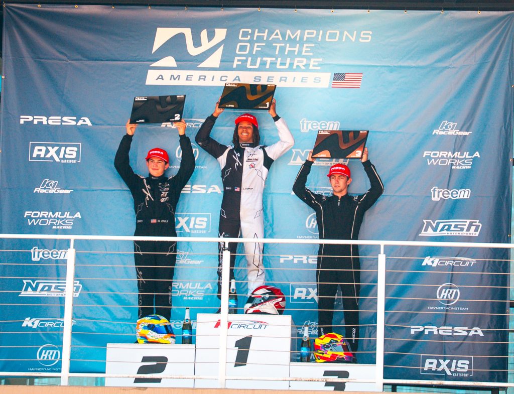 The Top 3 drivers from KA100 Senior hold up their trophies on the podium during Round 7 of Champions of the Future America